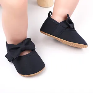 Detalle de zapatos de princesa para bebé niña en azul marino con suela blanda y lazo