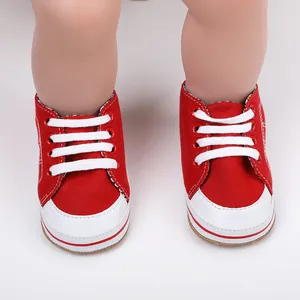 Close-up van rood-witte baby loopschoentjes van zacht canvas materiaal