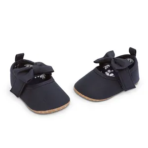 Detalle de zapatos de princesa para bebé azul marino con suela blanda y un lazo