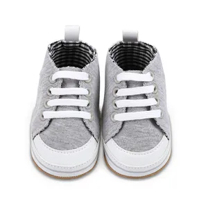 Detail van grijze baby-loopschoenen met een geruite binnenvoering