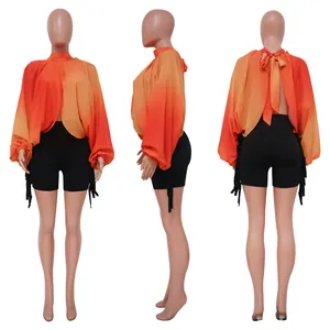 Viste da tre angolazioni di una camicetta in chiffon sfumato arancione e pantaloncini neri
