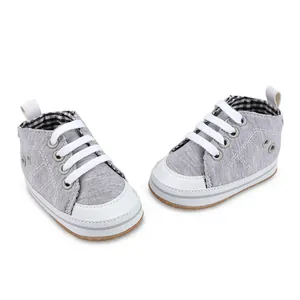 Gedetailleerd zijaanzicht van grijze katoenen baby-loopschoenen met witte veters