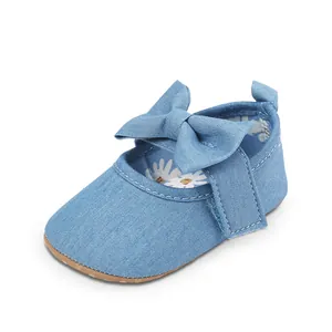 Detalle de zapatos vaqueros azules para bebé con lazo grande y forro con margaritas