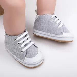 Detail van grijze stoffen baby wandelschoenen voor baby's op een mannequin voet.