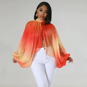 Primo piano del top in chiffon arancione sfumato con eleganti maniche a pipistrello