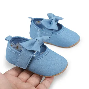 Primer plano de zapatos princesa para bebé en denim azul con lazo y suela muy suave.