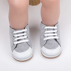 Gedetailleerd bovenaanzicht van grijze baby loopschoenen met witte neus en witte veters