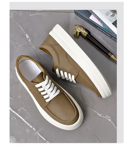 Top view of brown leather men's casual sneakers with thick white soles and white laces.