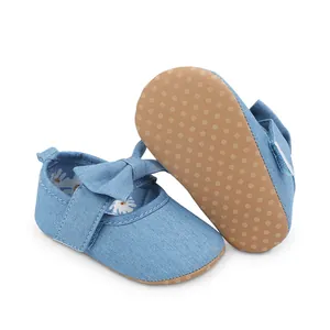 Detalle de zapatos de princesa para bebé niña en denim con suela blanda y lazo