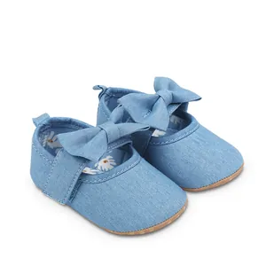 Detalle de zapatos de princesa en mezclilla para bebé niña con lazo decorativo