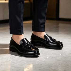 Primo piano di eleganti mocassini neri con nappe da uomo in pelle verniciata lucida