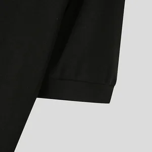 Detailed close-up view of a black men's t-shirt sleeve cuff with fine knit texture.