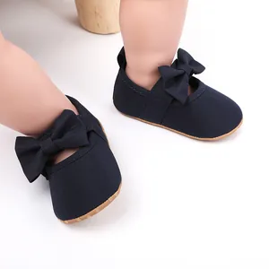 Détail des chaussures de princesse bleu marine pour bébé avec semelles souples et nœuds