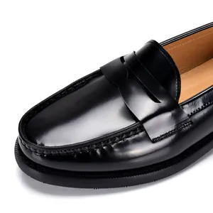 Primer plano de un mocasín penny de cuero negro pulido con forro de alta calidad