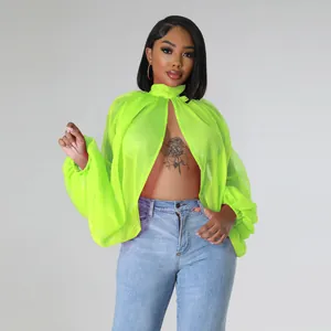 Camicetta in chiffon verde neon con maniche a pipistrello indossata da una modella