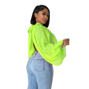 Dettaglio posteriore blusa in chiffon verde neon con maniche a pipistrello e lacci.