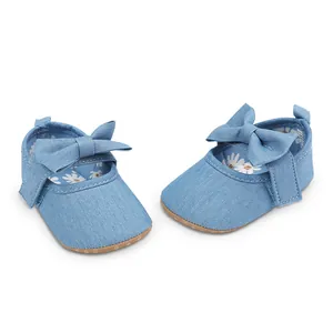 Détail de chaussures de princesse en denim bleu pour bébé fille avec nœud et doublure