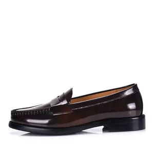 Perfil lateral de mocasines de cuero marrón oscuro brillante para hombre de estilo británico clásico.