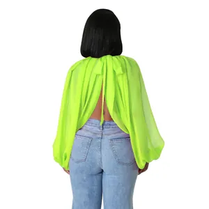 Vista posteriore di una blusa in chiffon verde neon con maniche a pipistrello e schiena scoperta