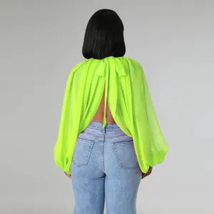 Vista posteriore dettagliata di un top in chiffon verde neon con maniche a pipistrello e fiocco