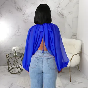 Vista dettagliata di una camicetta in chiffon blu reale con maniche a pipistrello e laccetti