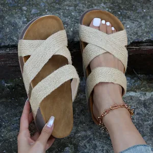 Detail van casual dames sandalen met platform en beige geweven gekruiste bandjes.