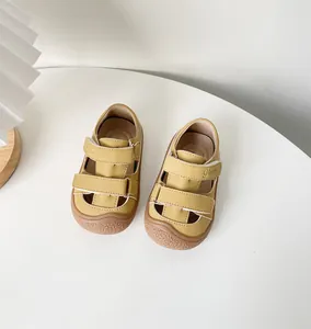 Vue de dessus de sandales de marche jaunes pour bébés avec velcro sur table blanche