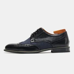Vista laterale di classiche scarpe derby brogue in pelle nera e tessuto blu scuro