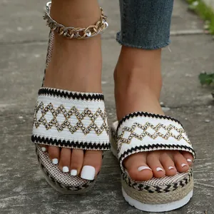 Close-up of ethnic woven pattern on women's platform espadrille slide sandals