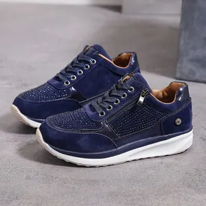 Vista dettagliata di sneakers blu navy con strass scintillanti e cerniera laterale.