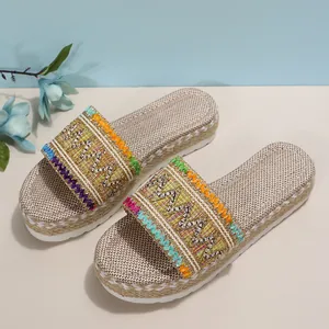 Detail of ethnic style women's platform slides featuring colorful woven straps and rope soles