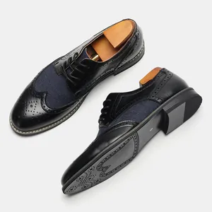 Dettaglio delle classiche scarpe derby brogue da uomo in pelle nera e tessuto blu patchwork