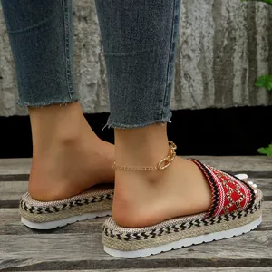Close-up side view of ethnic style platform slide sandals on feet with woven texture