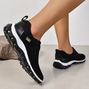 Vue latérale de baskets noires pour hommes avec semelles blanches et accents jaunes
