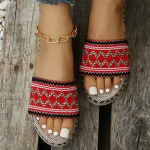 Close-up of ethnic style red woven platform espadrille sandals on wood background.