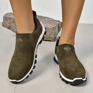 Gros plan de mocassins pour hommes en daim olive avec fond de roche grise naturelle