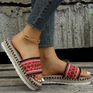 Detailed macro view of women's ethnic style platform slides with red woven patterns