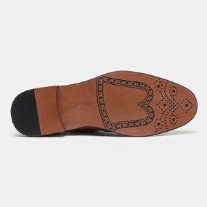 Vista dettagliata della suola delle scarpe classiche marroni con motivi brogue