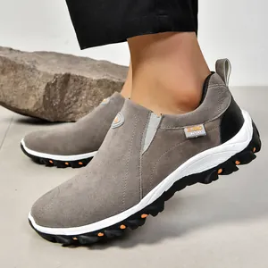 Gros plan sur chaussures d'extérieur en daim gris avec détails orange sur semelle