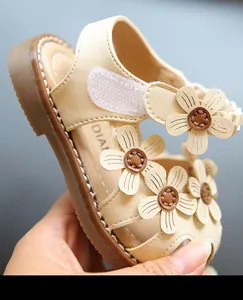 Nahaufnahme beiger Babysandalen für Mädchen mit Blumenverzierung und weicher Sohle.