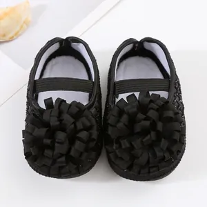 Vue détaillée des chaussures de princesse pour bébé avec applique de fleur en ruban