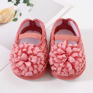 Vue détaillée de chaussures de princesse roses pour bébé avec une grande fleur décorative