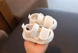 Detail view of white toddler sandals featuring soft quilted design and anti-slip rubber soles.