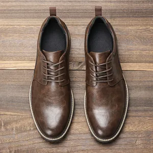 Vista dall'alto di scarpe casual da uomo in pelle marrone su fondo in legno