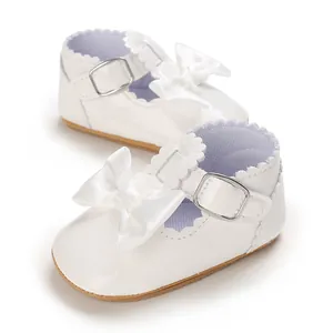 Paio di scarpe primi passi bianche in vernice per neonata con fiocco elegante e fibbia