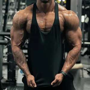 Detailed macro view of black cotton gym stringer tank top worn by a muscular athlete in a gym