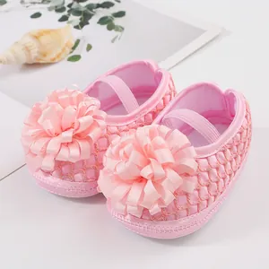 Gros plan de chaussures de princesse roses pour bébé avec ruban et semelle souple.