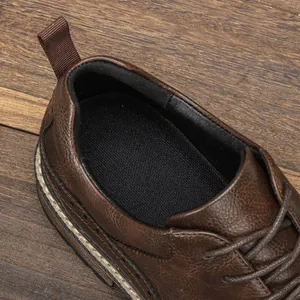 Primo piano di scarpa casual da uomo in pelle marrone con dettagli brogue