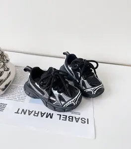 Close-up detail of black and white baby sneakers with mesh upper and soft walking soles