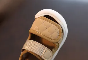 Close-up of quilted stitching and protective toe cap on soft sole baby sandals